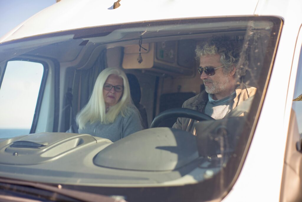 Senior couple enjoying a road trip in their RV, exploring the scenic landscapes of Portugal.