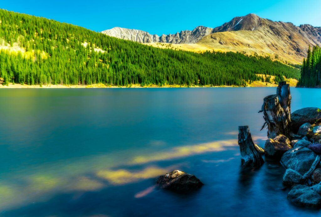 Tranquil mountain lake in Breckenridge, Colorado surrounded by lush forests and scenic landscapes.